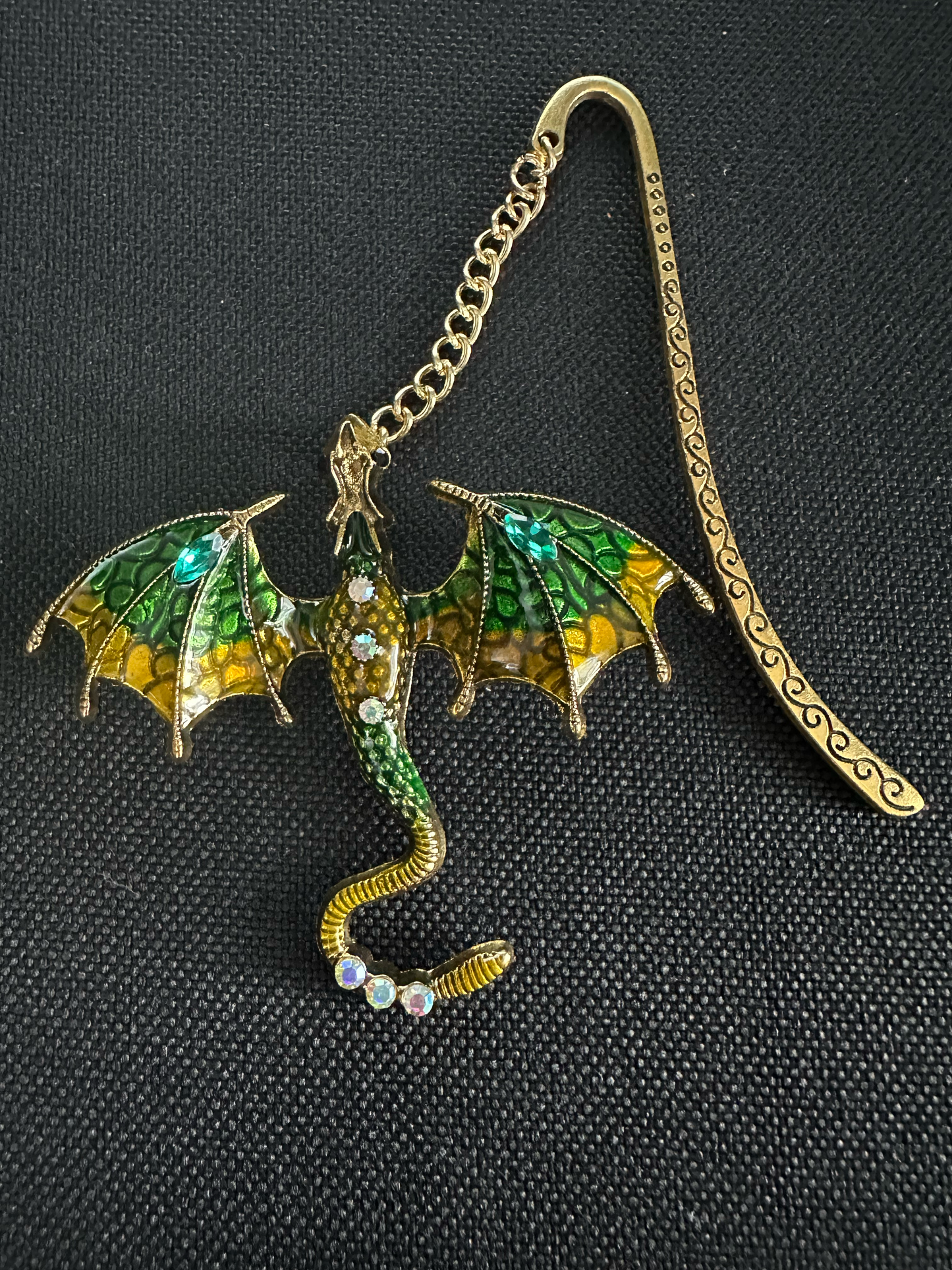 Decorative dragon-shaped bookmark with gold and green colors on a black background