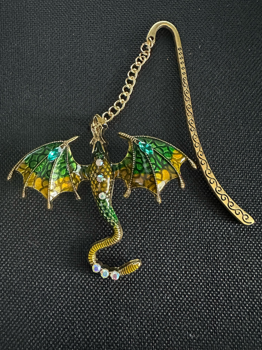 Decorative dragon-shaped bookmark with gold and green colors on a black background